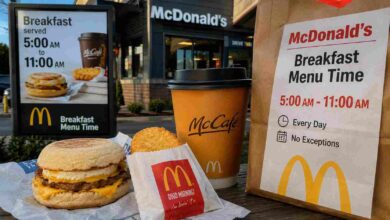 A McDonald's McMuffin, hash brown, and coffee displayed next to a sign showing the exact mcd breakfast menu time.