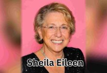 A color portrait of older Sheila Eileen smiling in a black sequined dress against a pink background.